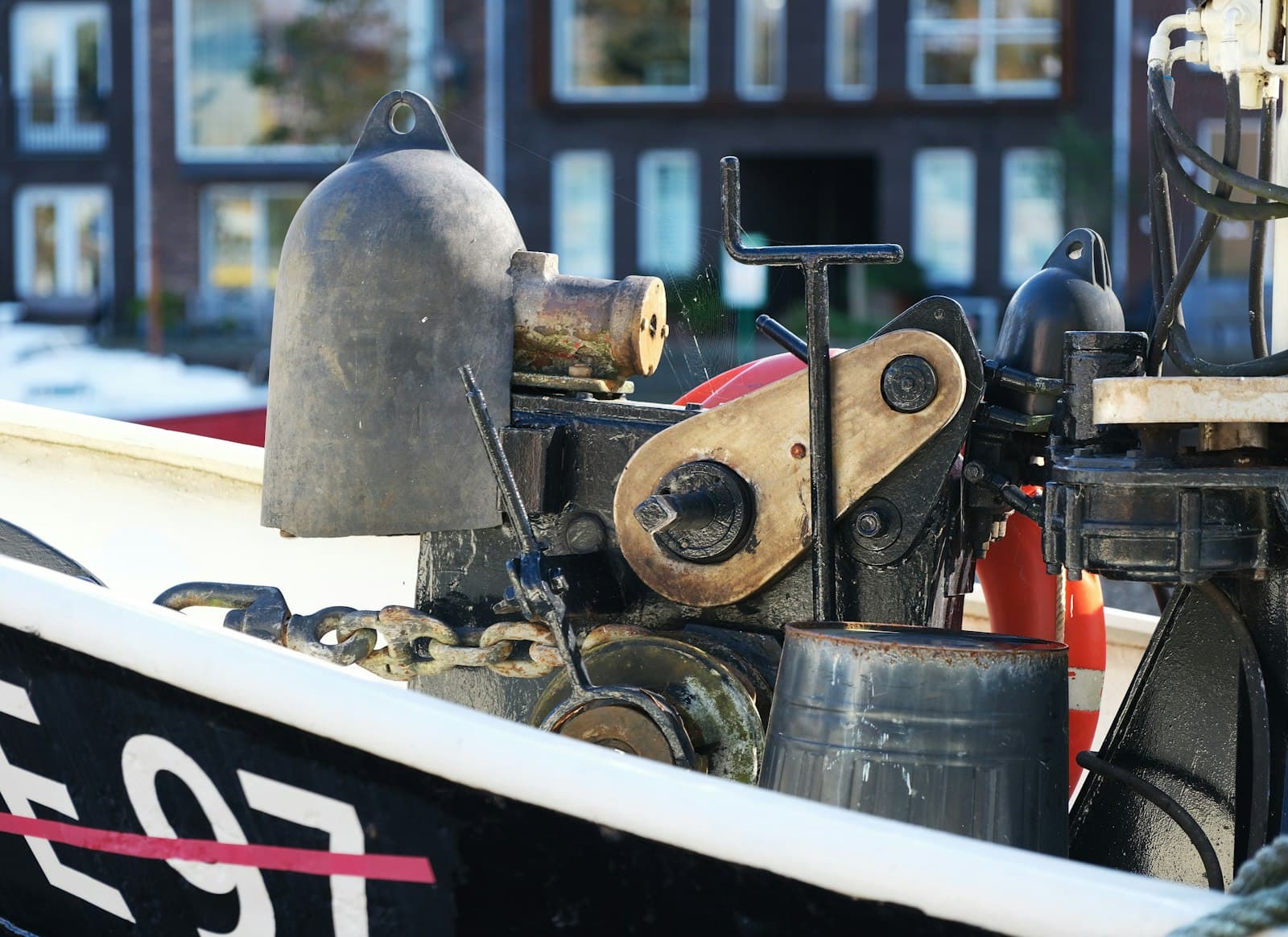 Winch, fenders and deck machinery on a working boat alongside a quay
