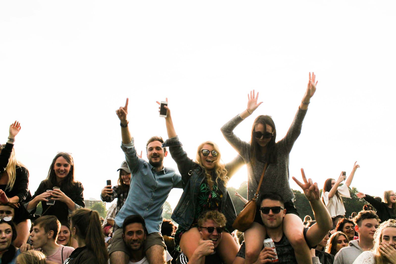 A crowd with raised hands at an outdoor music festival